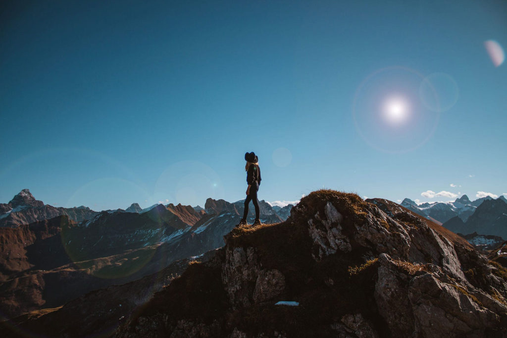man standing on a mountain in the sun